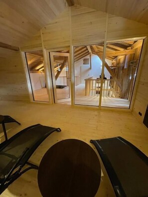 A room with a wooden floor, a round table, and two exercise bikes. - Alpenhof Landhotel Restaurant (Oberaudorf)