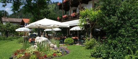Frukost och lunch serveras, med utsikt mot trädgården