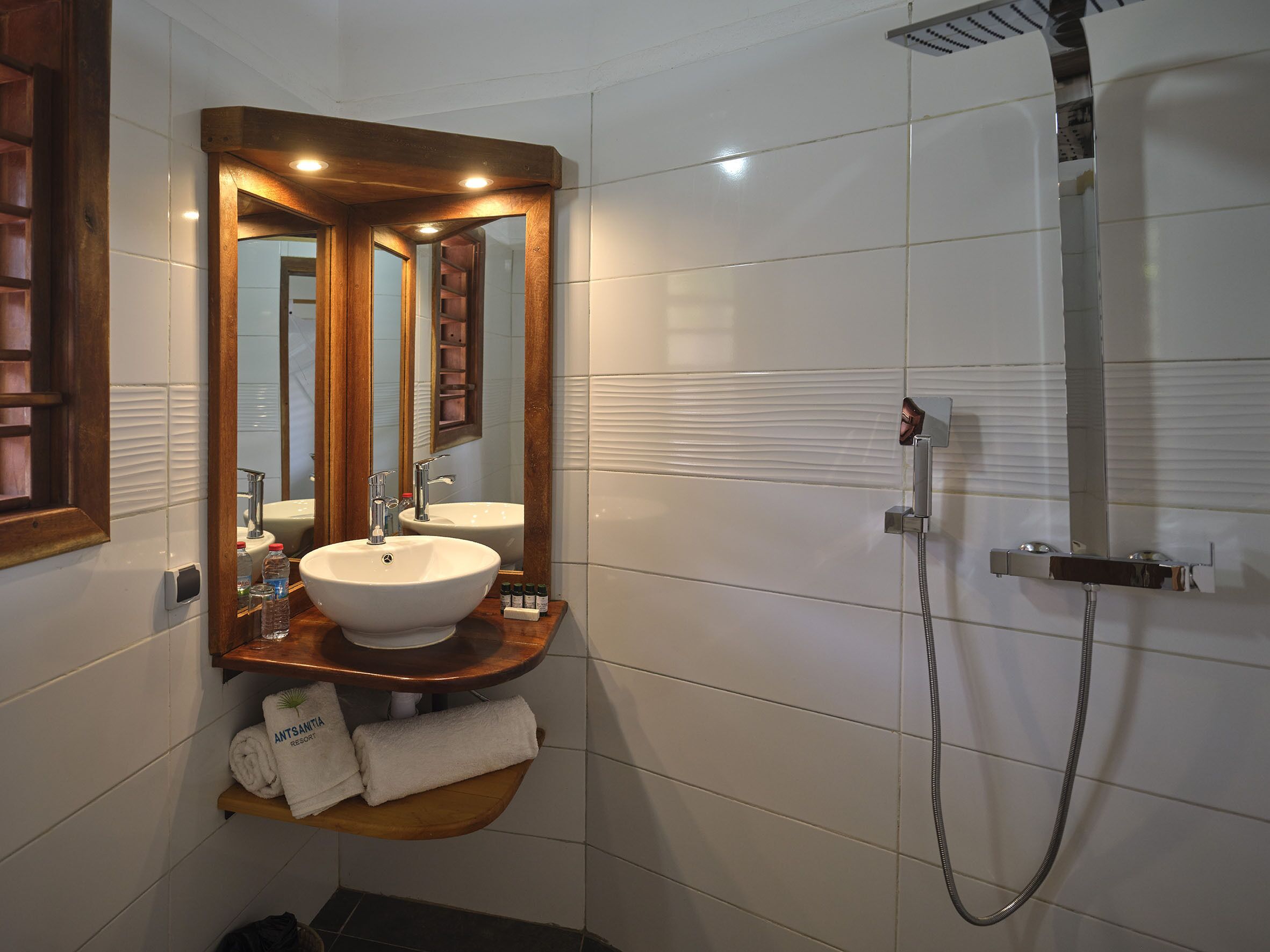 Un baño con lavamanos, espejo y ducha.