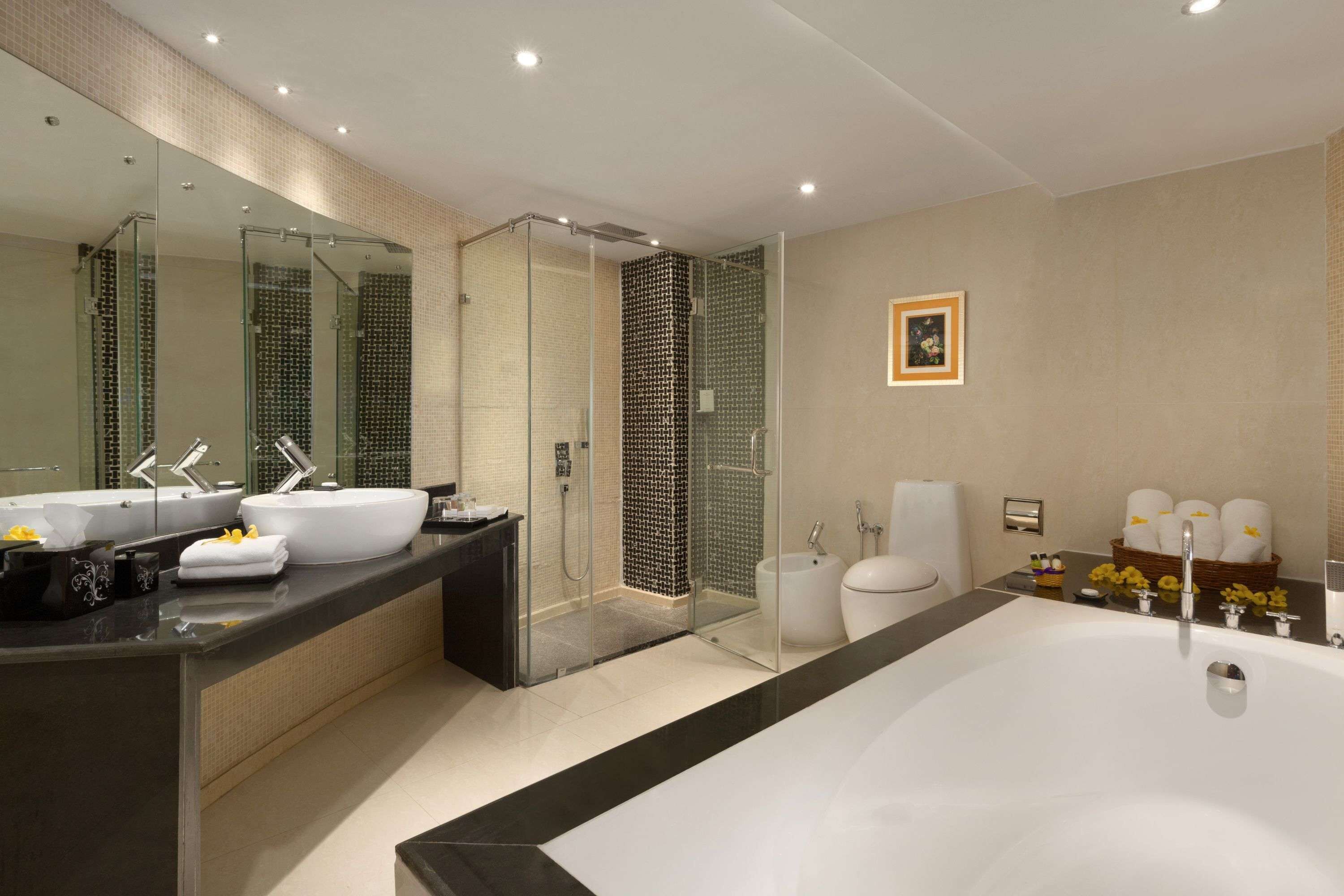 Une salle de bain moderne dotée d’une grande baignoire, d’une douche séparée et d’un meuble-lavabo avec deux vasques.