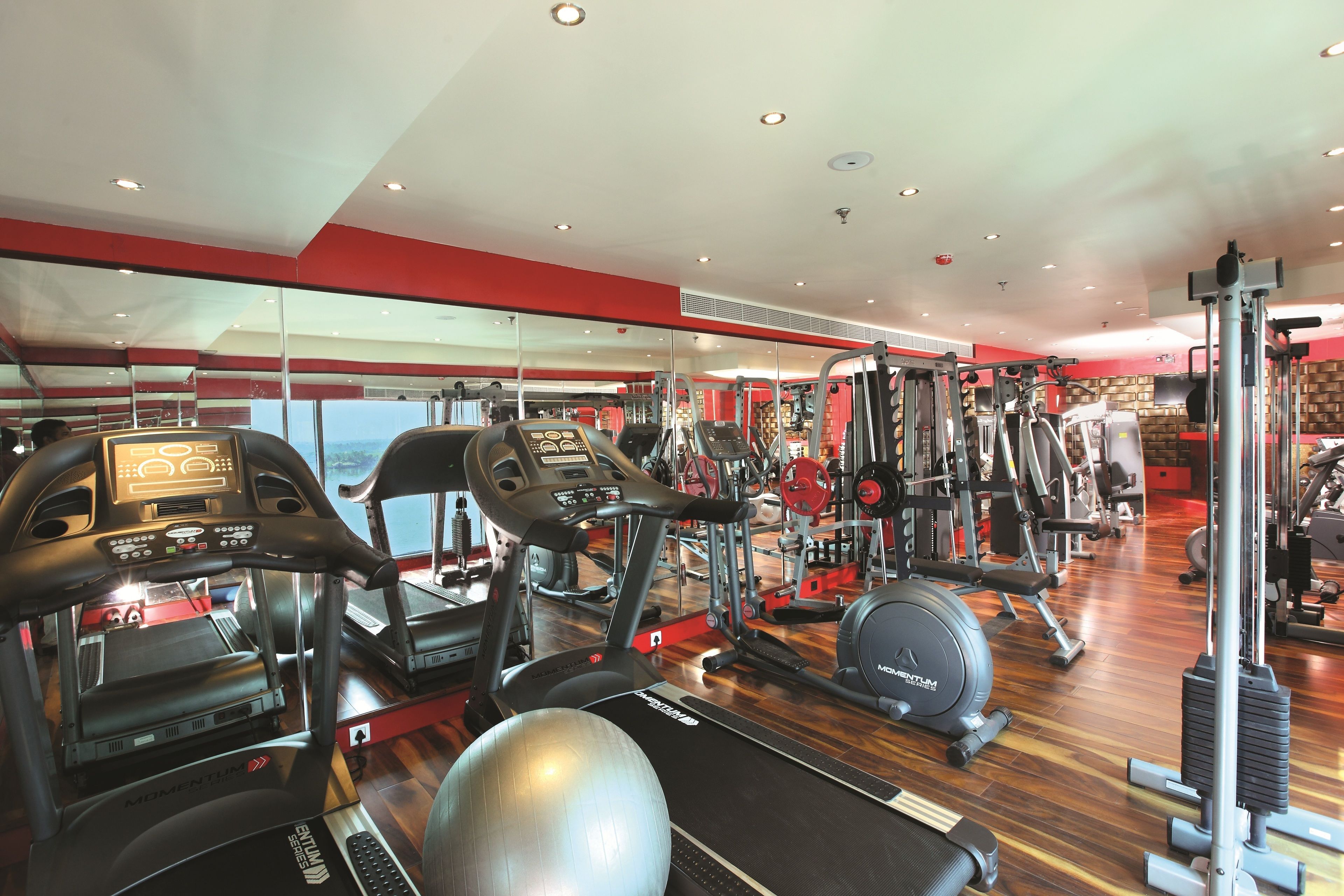 A gym with treadmills, elliptical machines, and weight equipment.