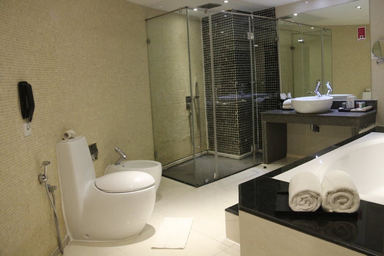 Une salle de bain moderne avec une douche à parois de verre, une grande baignoire et des toilettes séparées.