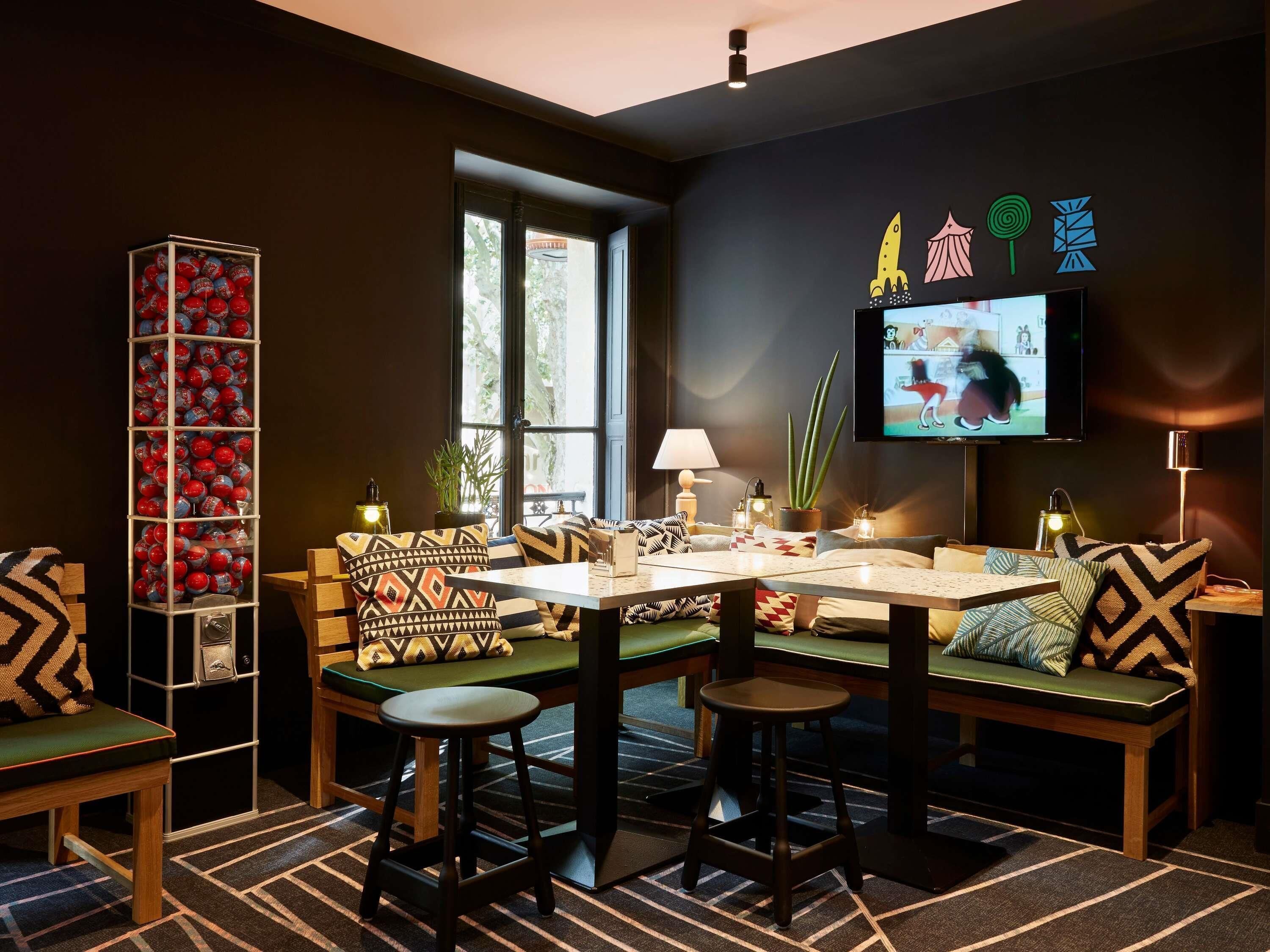 Un salon moderne comprenant un ensemble de canapés, une table basse, un téléviseur et une grande étagère décorative.