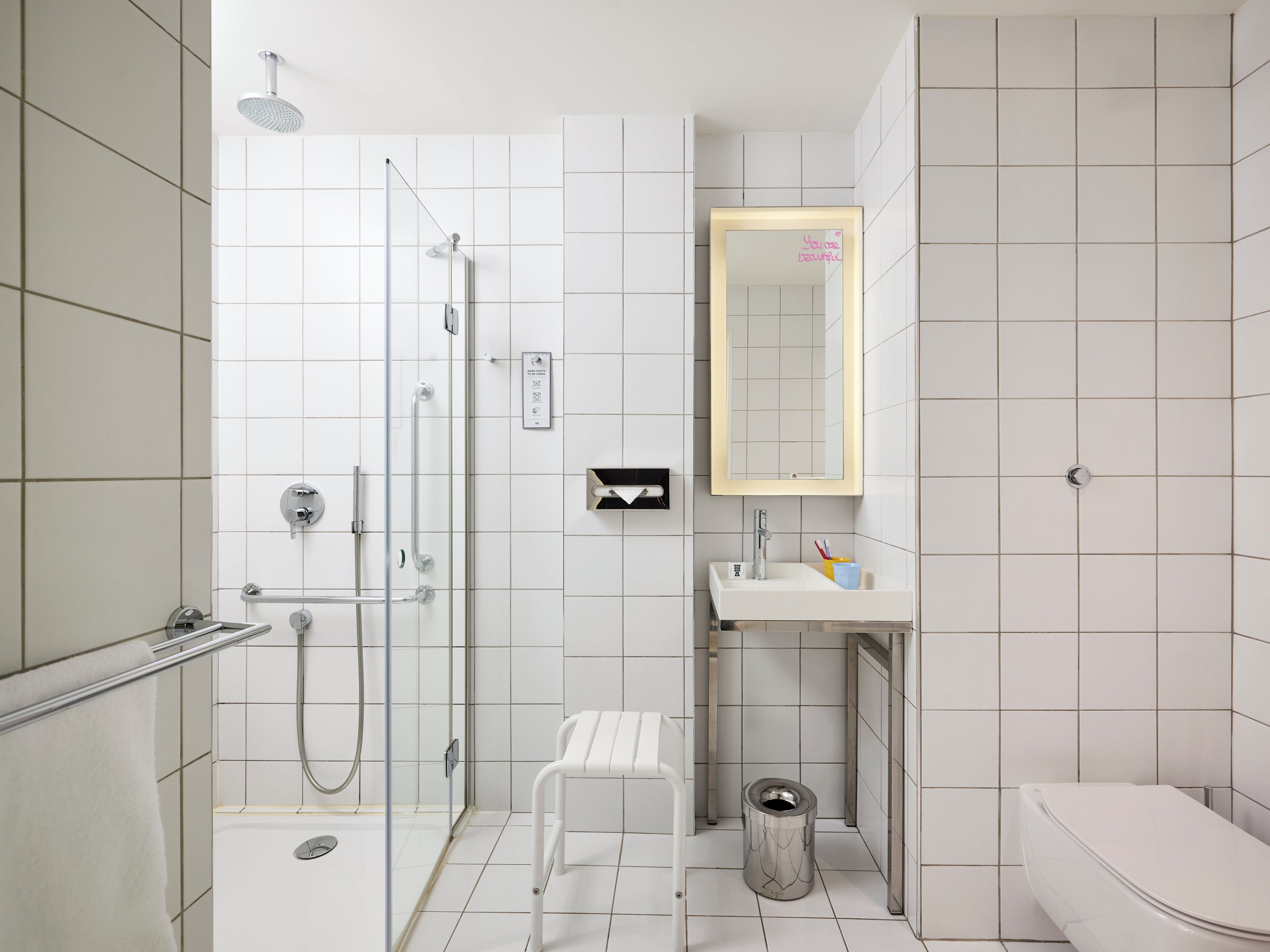 Un baño moderno con cabina de ducha, inodoro y lavabo con espejo.