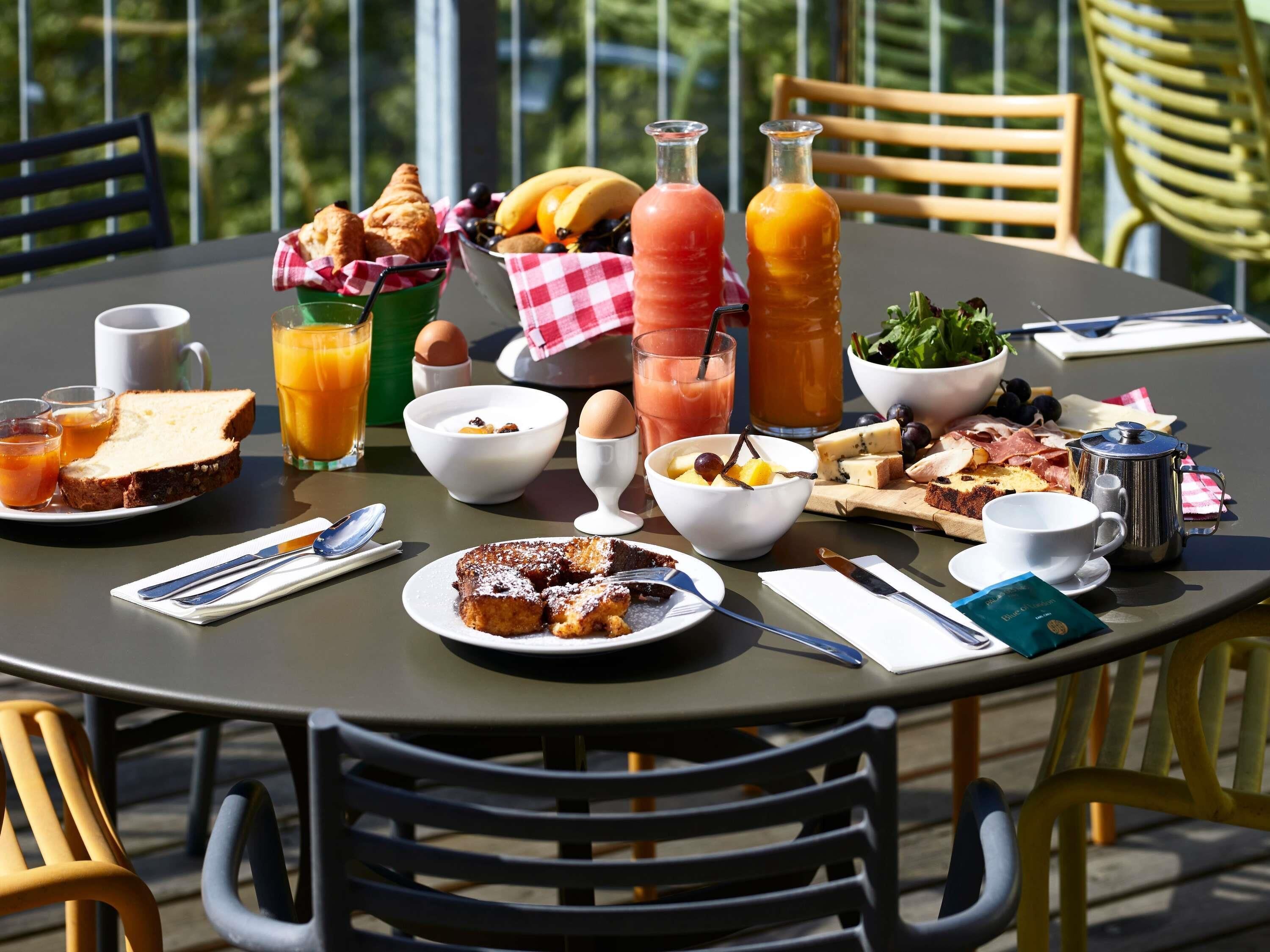 Una mesa redonda con alimentos para el desayuno, como tostadas, huevos y fruta.