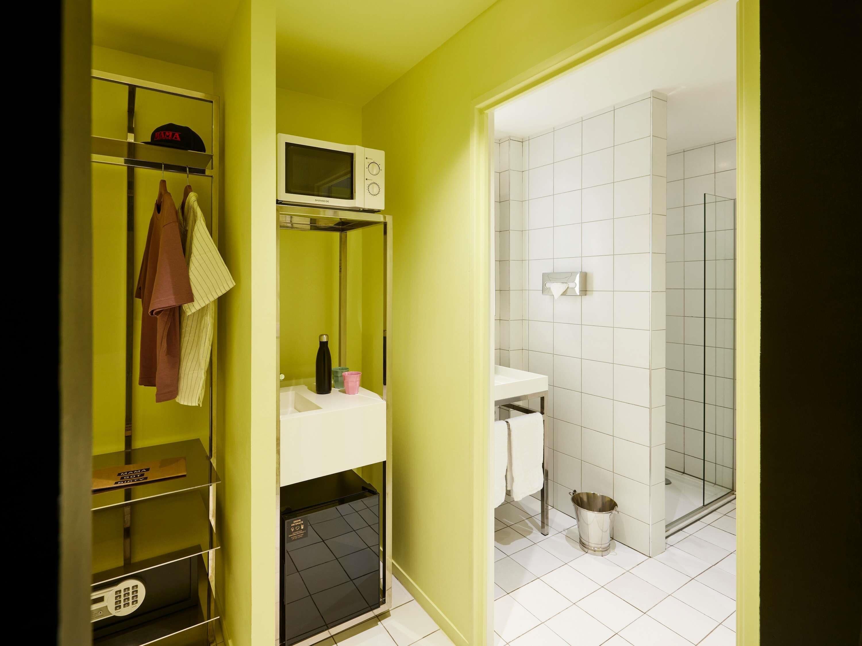 A bathroom with a white sink, a mirror, a towel rack, and a shower area.