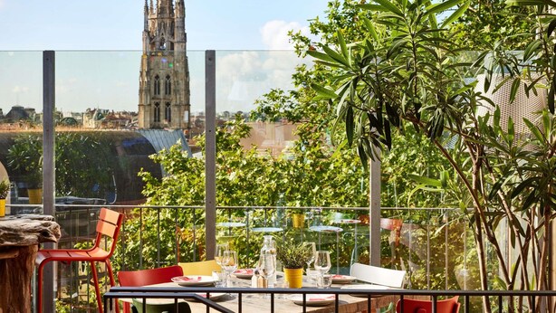 Un comedor con una mesa para dos, sillas y vistas a una catedral.
