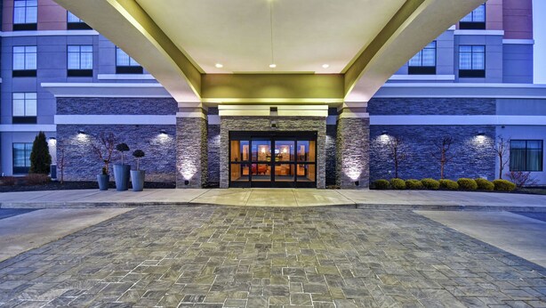 A hotel entrance with a stone facade, a glass door, and a covered walkway. - Homewood Suites by Hilton DuBois, PA (DuBois)