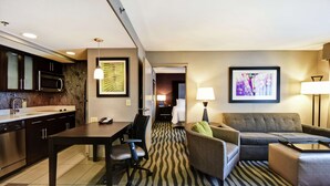 A hotel room with a kitchenette, a dining area, a sofa, and a bed. - Homewood Suites by Hilton DuBois, PA (DuBois)