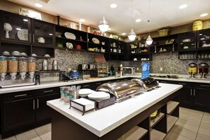 A well-equipped kitchen with various appliances, a buffet setup, and neatly organized shelves with kitchenware. - Homewood Suites by Hilton DuBois, PA (DuBois)