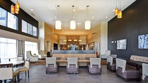 A modern hotel lobby with a reception desk, seating area, and large windows. - Homewood Suites by Hilton DuBois, PA (DuBois)