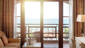 Et værelse med havudsigt, en balkon med gelænder, et bord med spand og et glas, samt en stol.