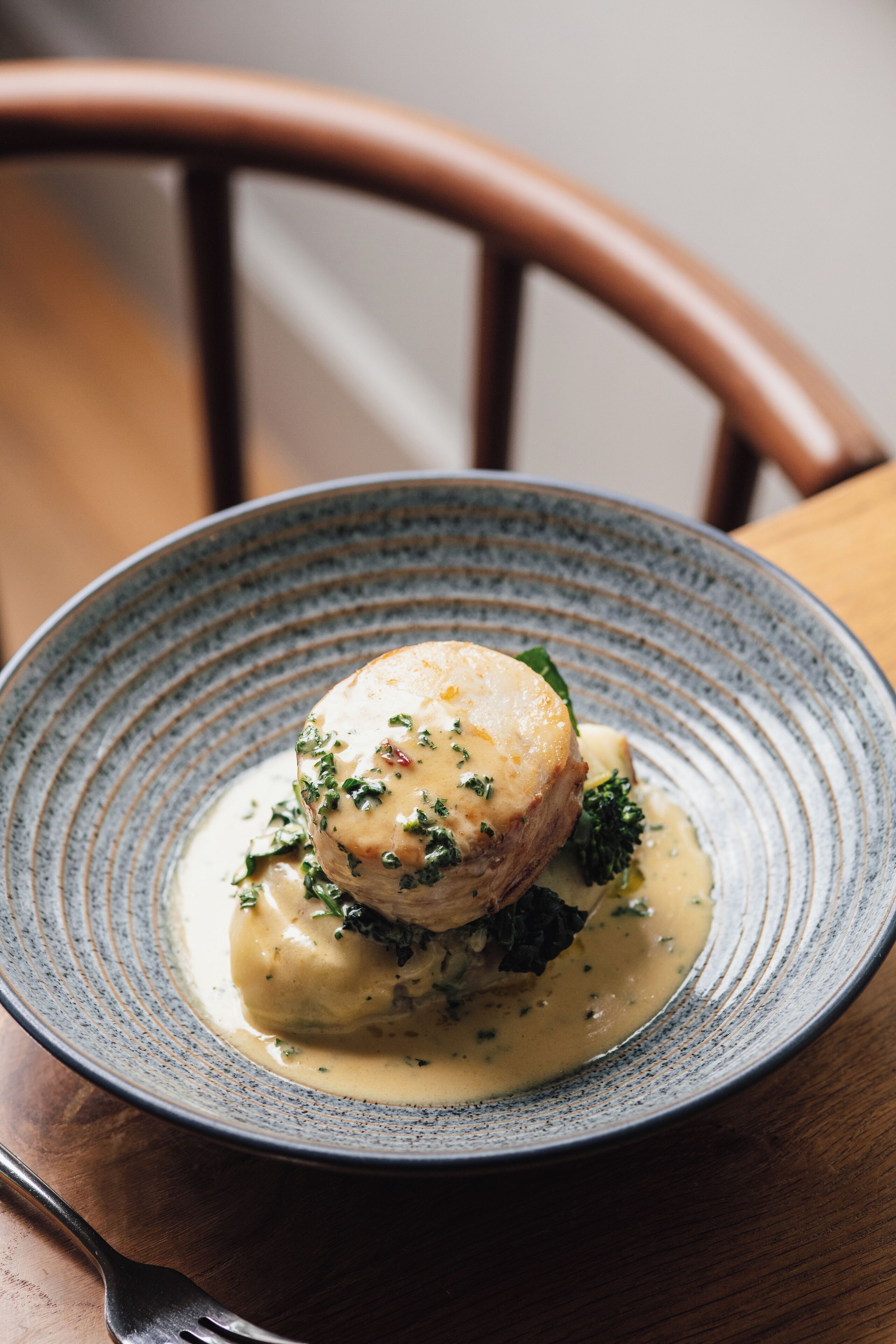 A plate of food with a creamy sauce and herbs.