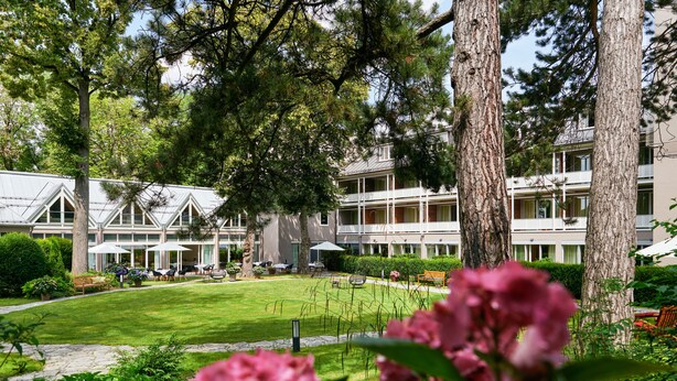 Un hôtel doté d’un jardin, d’un espace extérieur aménagé pour s’asseoir et de plusieurs étages.
