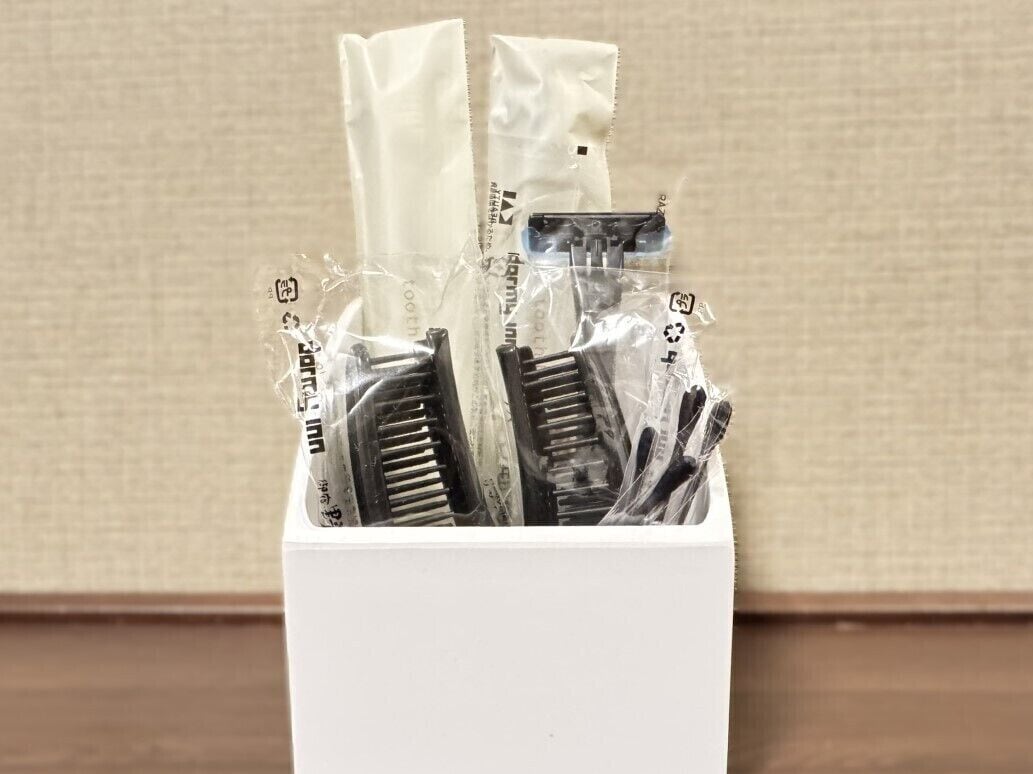 Une boîte blanche contenant divers outils de coiffure, notamment des peignes et des brosses, dont les étiquettes d’emballage sont bien visibles.