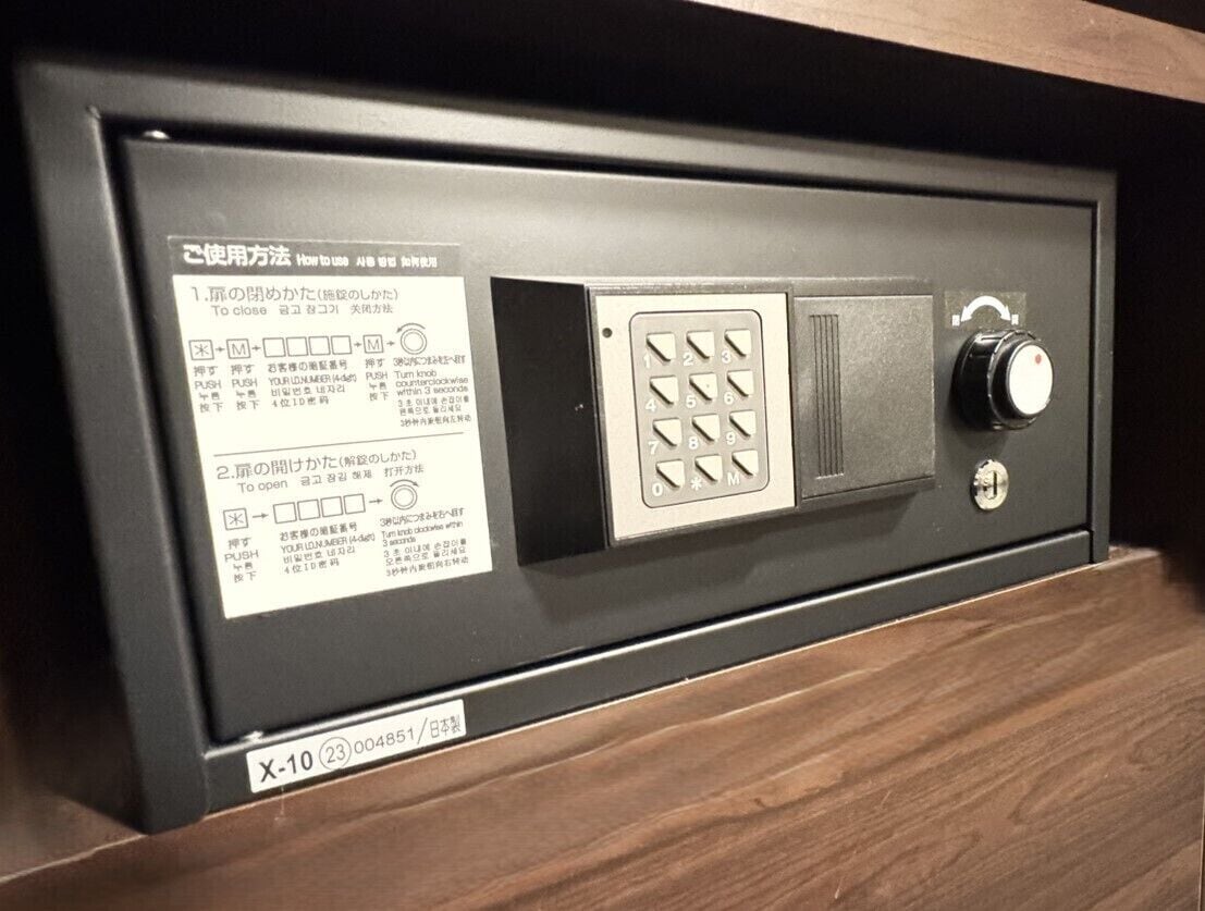 Et pengeskab med et tastatur og en kombinationslås, ledsaget af instruktioner på japansk.