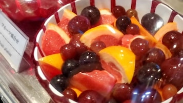 A bowl of mixed fruits including grapes, oranges, and watermelon slices.