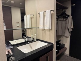 Un baño con dos lavamanos, un espejo y un perchero para toallas.