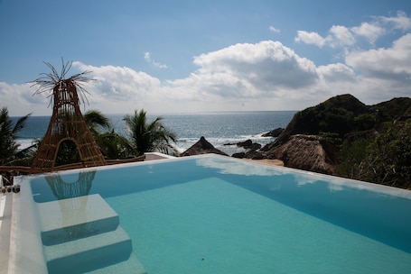 Una piscina al aire libre, sillones reclinables de piscina. El Alquimista Yoga & Spa