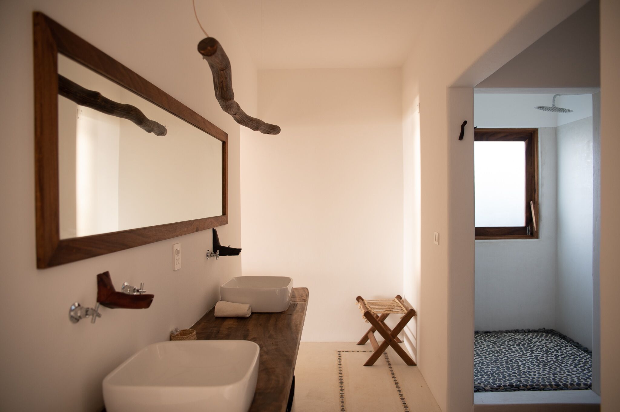 A bathroom with a large mirror, a wooden vanity, a bathtub, and a shower area.