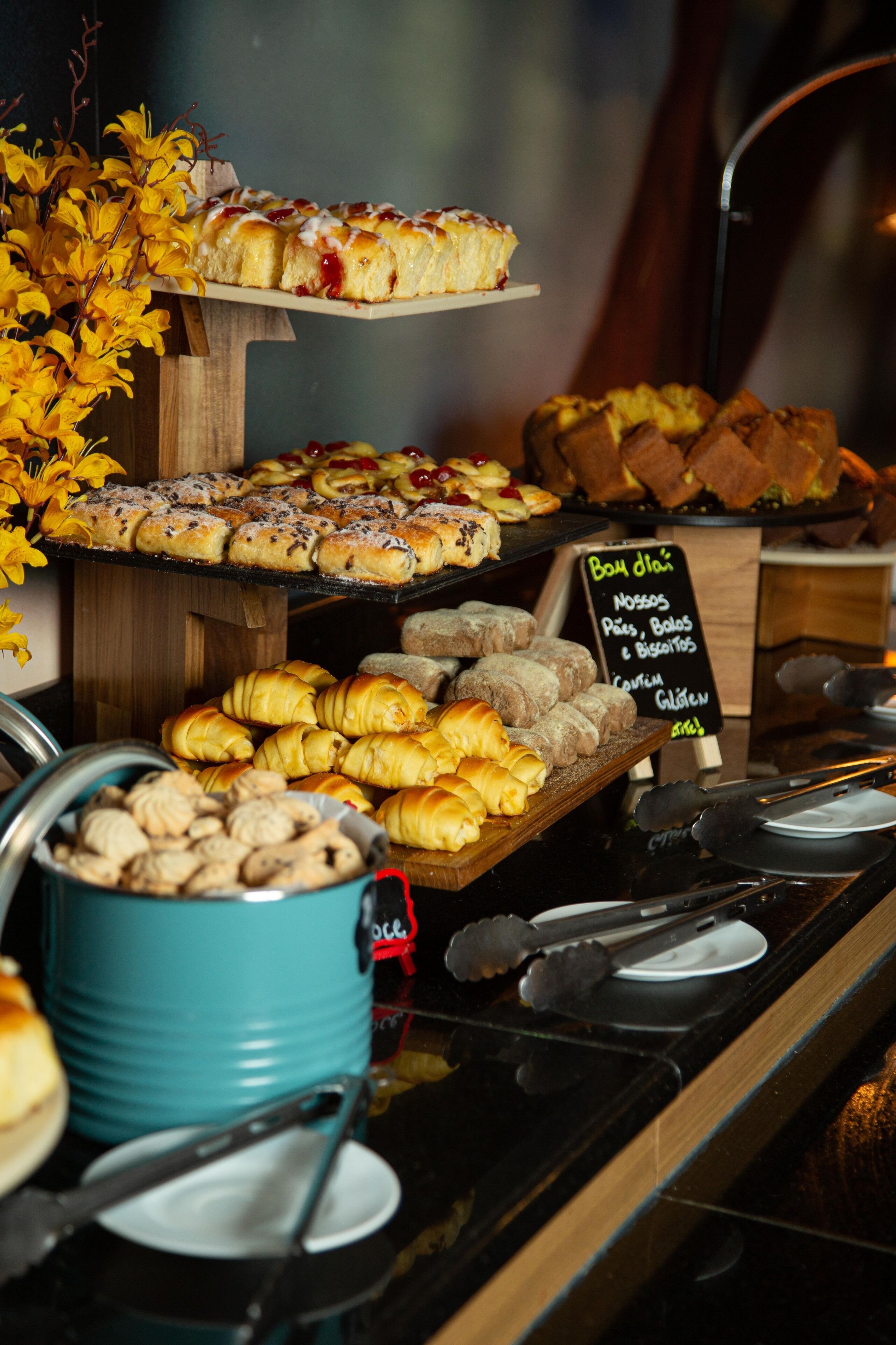 A buffet with various baked goods including pastries, bread, and desserts.