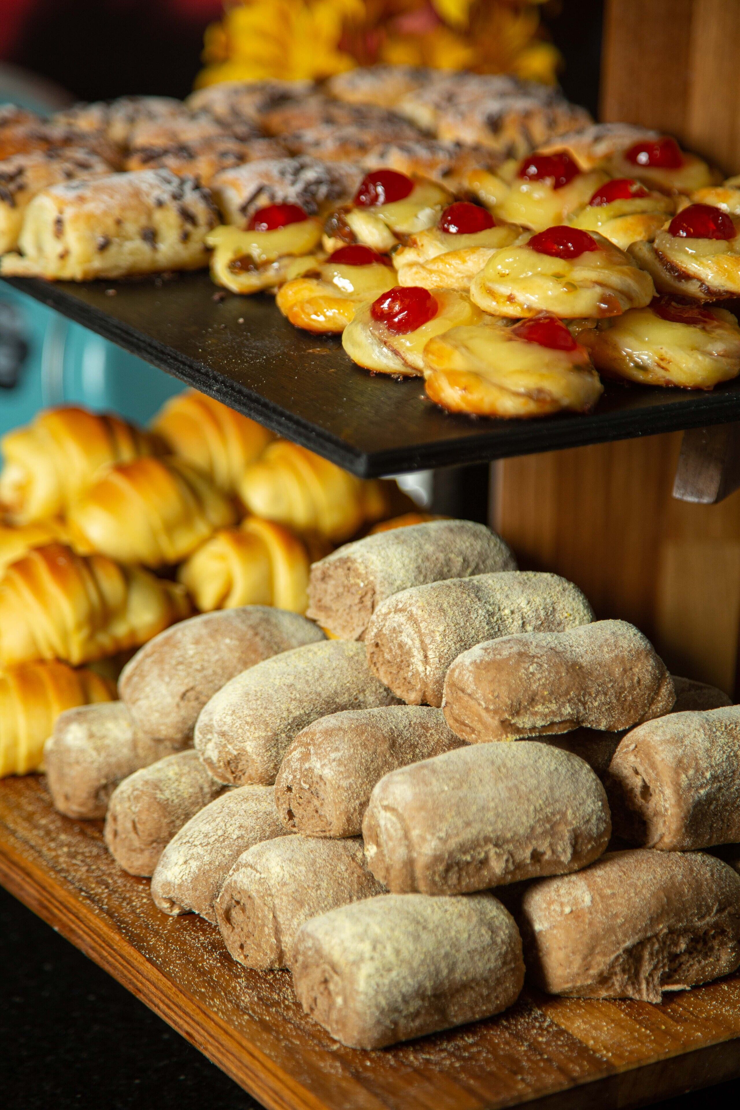 Variedad de pasteles expuestos, incluyendo croissants y dulces bañados en chocolate.