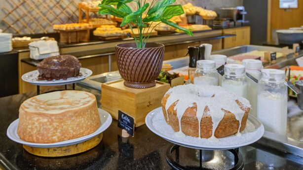 Un buffet con diversi dolci e una pianta in vaso.