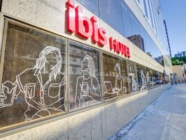 Un hôtel doté de grandes fenêtres où l’on peut admirer des dessins linéaires représentant des personnes.
