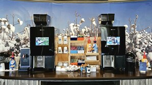 A coffee station with two coffee machines, a water dispenser, and various coffee-related items. - Holiday Inn Express & Suites Perry-National Fairground Area, an IHG Hotel (Perry)