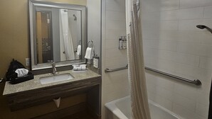 Ein Badezimmer mit Waschbecken, Spiegel und Dusche.