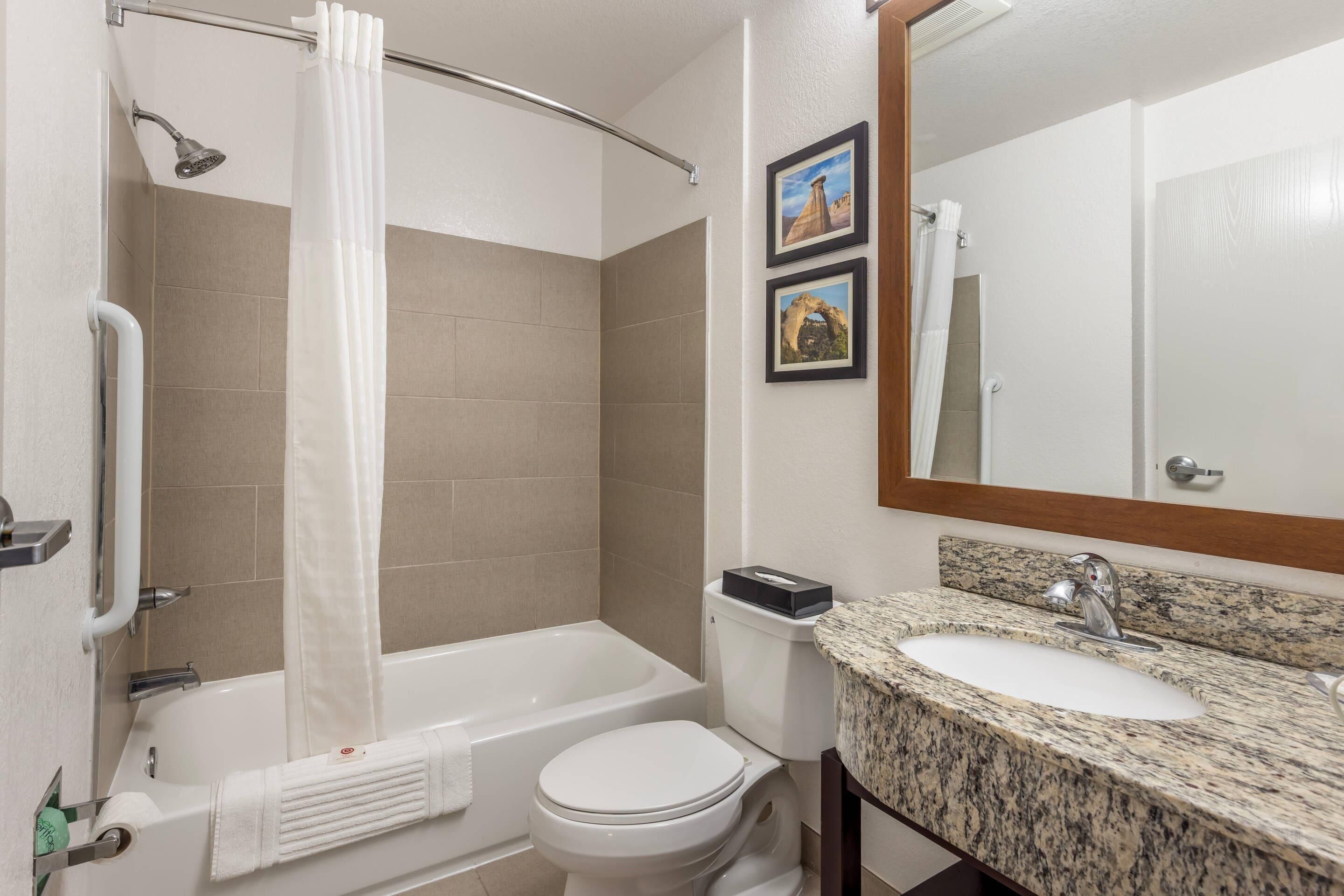 Un baño con bañera, inodoro y lavamanos.