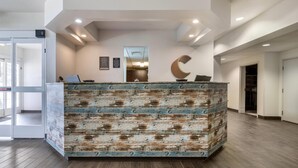 Un espace d’accueil doté d’un comptoir de réception en bois rustique, d’une décoration en forme de croissant de lune et d’un design moderne au plafond.