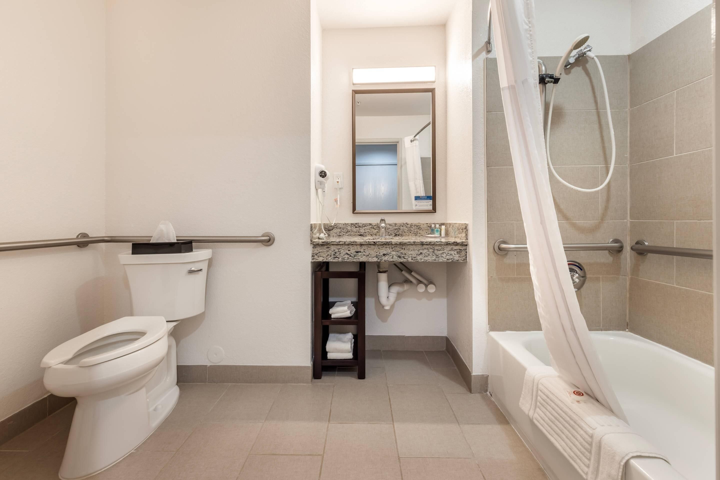 A modern bathroom with a toilet, sink, and bathtub.