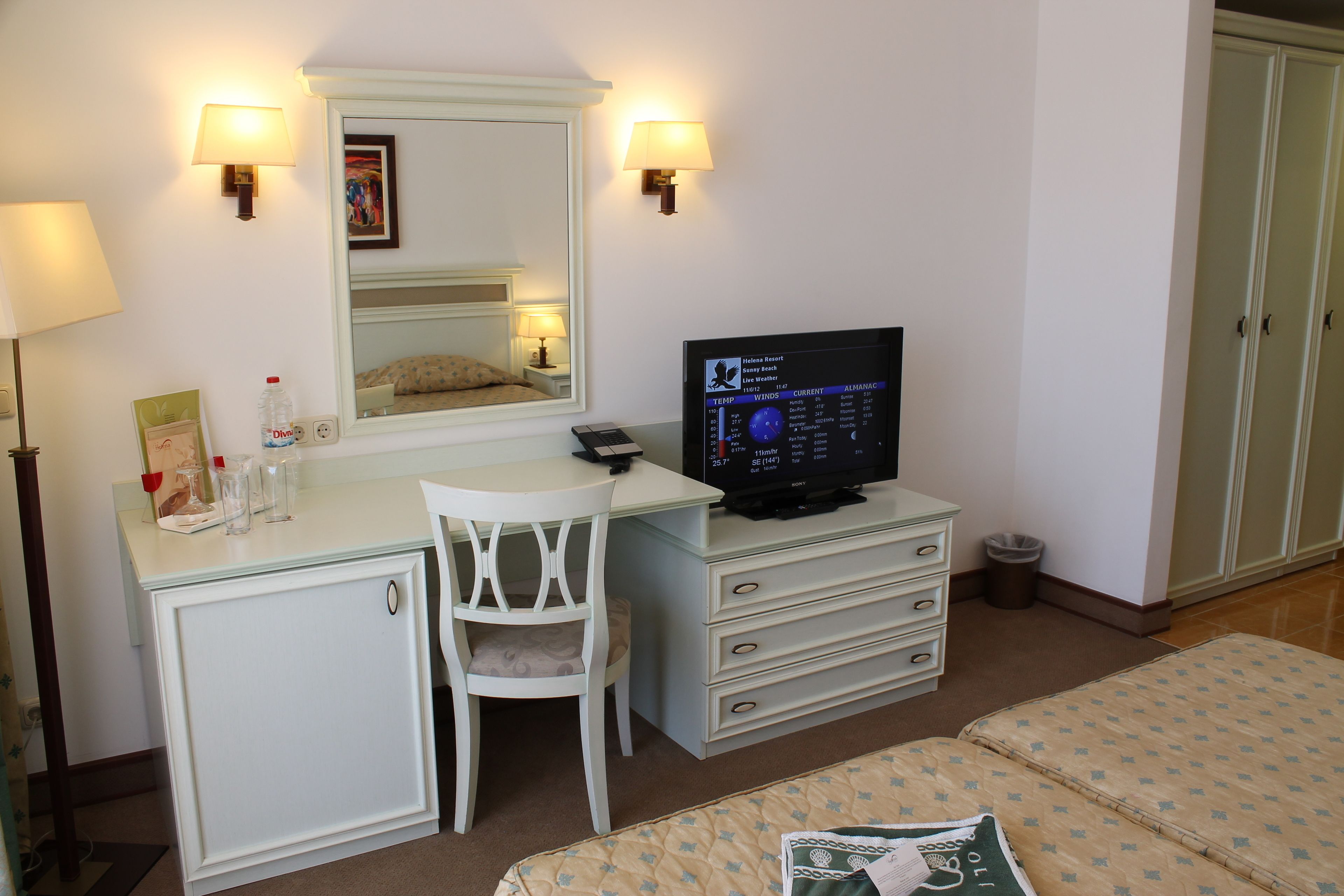 Una habitación de hotel con escritorio, silla, televisor y cama.
