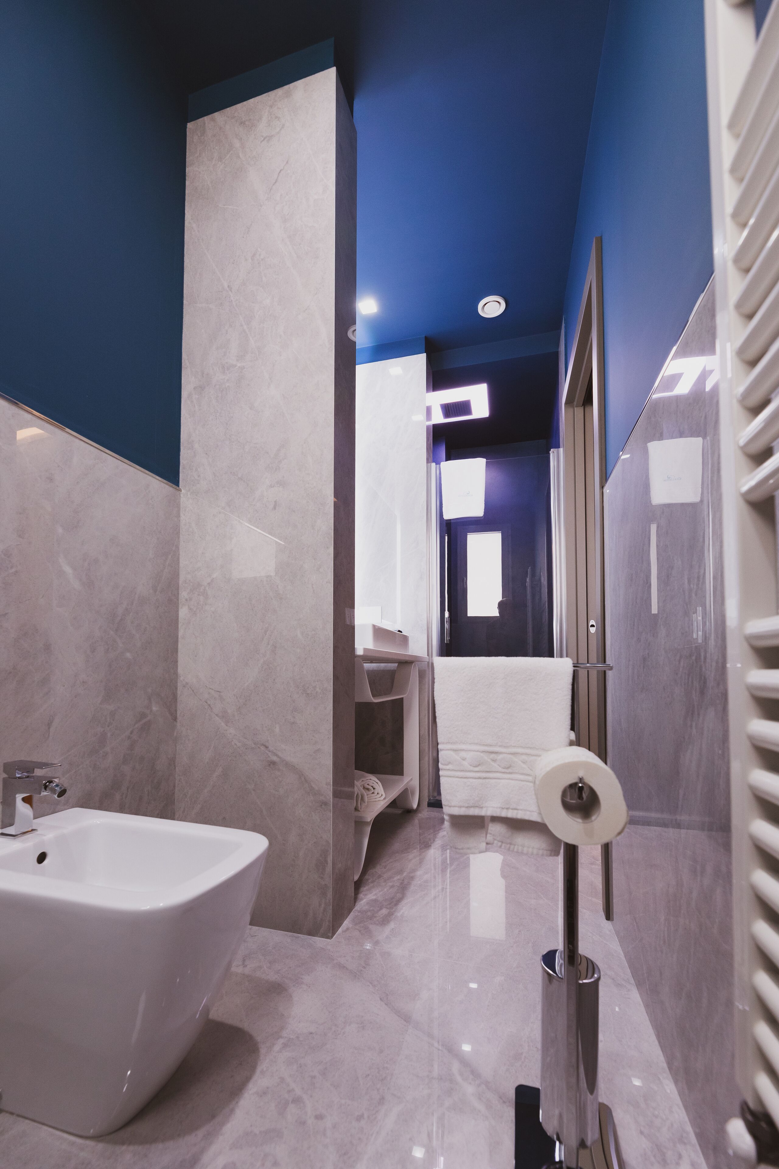 Een moderne badkamer met een wit wastafelmeubel, een handdoekhouder en een toiletrolhouder.