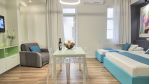Ein modernes Wohnzimmer mit Esstisch, Sofa und Sesseln.