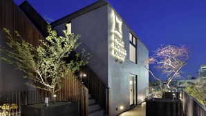 A modern building with a staircase, a sign reading 'PRESERVE HOSTEL KYOTO,' and two trees in front. - Piece Hostel Kyoto (Kyoto)