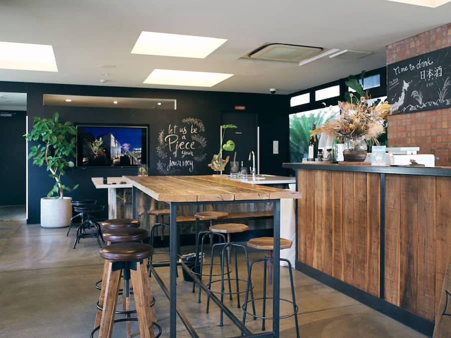 Ein modernes Café mit Holztresen, Barhocker und einer Tafel mit motivierenden Sprüchen.