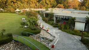 A paved pathway leading to a building with a thatched roof, surrounded by greenery and potted plants. - Brys Caves (Salt)