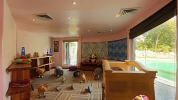 Relax and unwind in this inviting room, featuring a comfortable bed and seating area, perfect for families with kids.