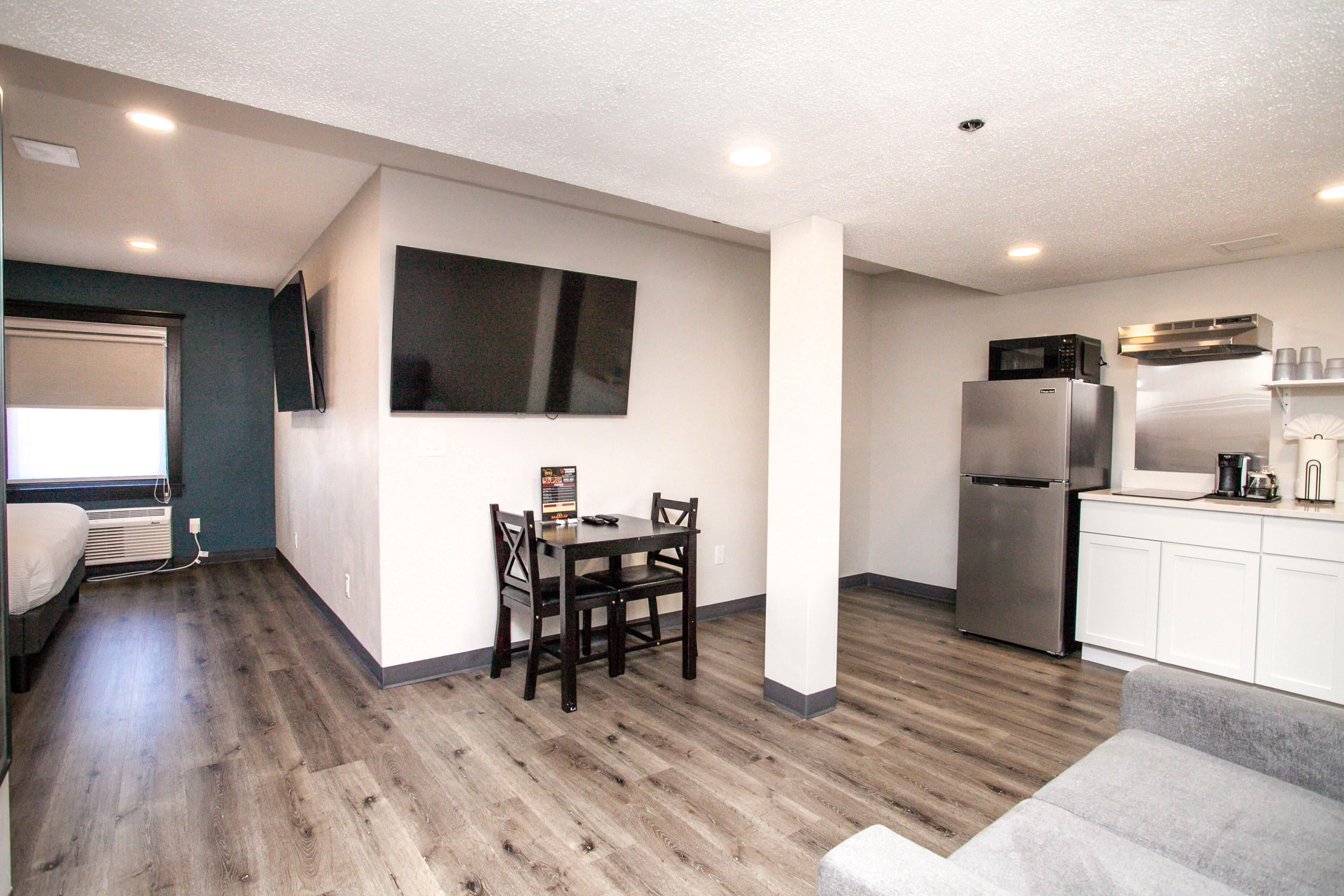 A compact living space with a dining area, kitchenette, and a seating area.