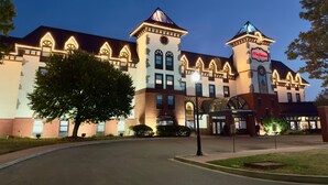 Ein großes, historisches Hotel mit einem markanten Turm und Bogenfenstern, mit einer gut beleuchteten Eingangshalle und einem angelegten Innenhof.