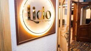 Ein gerahmtes Schild mit der Aufschrift "Lidlo Lounge", beleuchtet durch einen Kreislichtbogen.
