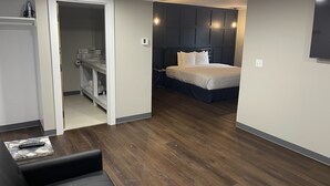 Ein modernes Schlafzimmer mit einem großen Bett, einem begehbaren Kleiderschrank und einer Sitzecke mit Couchtisch.
