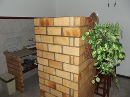 Una cocina con pared de ladrillo, un lavamanos y una planta en maceta.