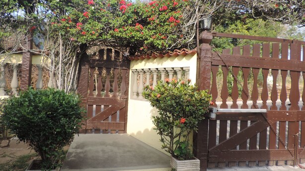 A gated entrance with a concrete pathway leading to a building. - Flats Paguru (Búzios)