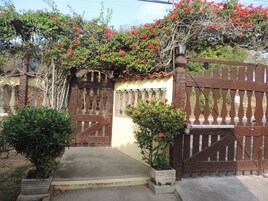 Una entrada con portón y un camino de concreto que lleva a un edificio.
