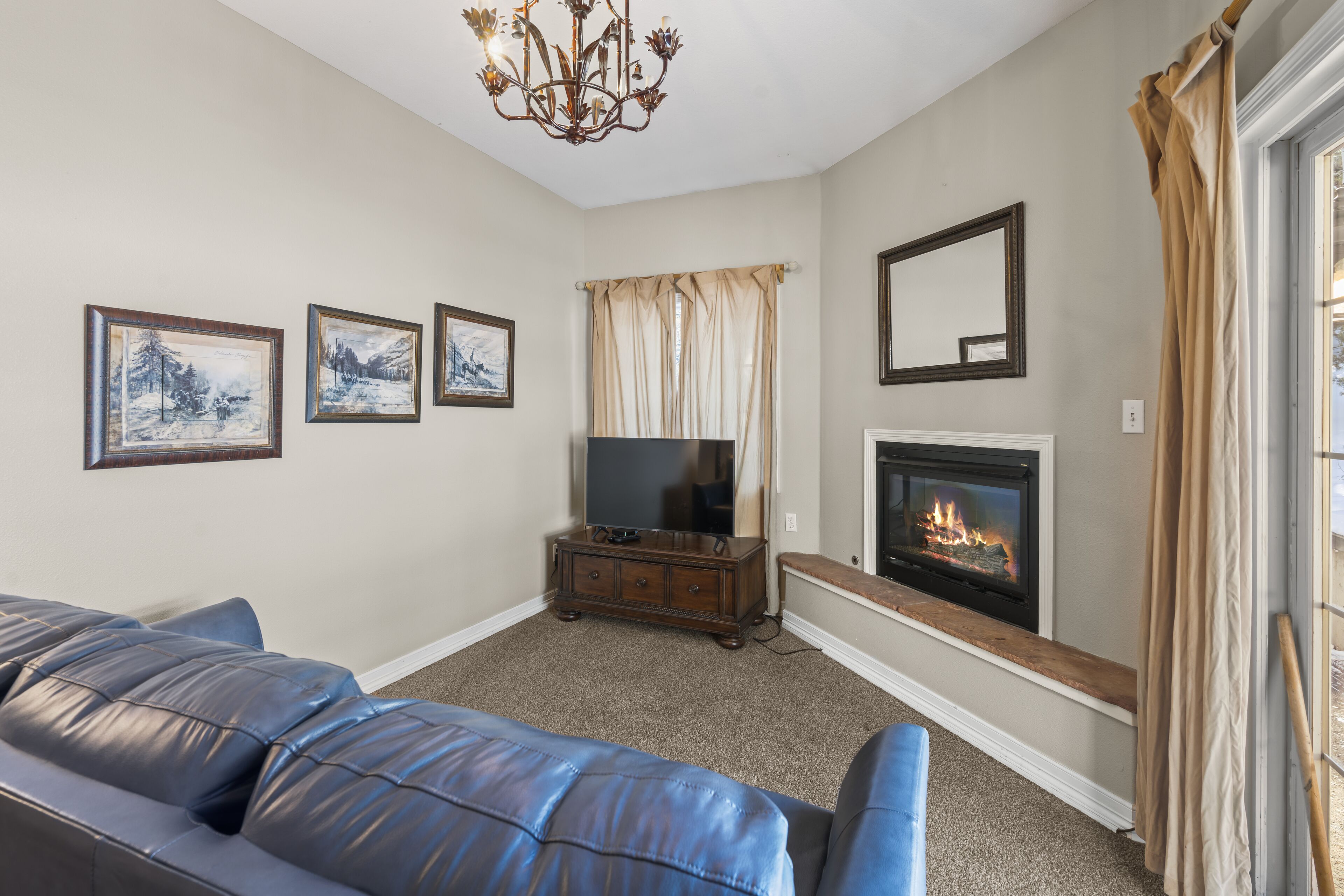 A living room with a fireplace, a television, and a sofa.