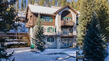A lodge with a two-story structure, a balcony on the upper floor, and a sign indicating its name.