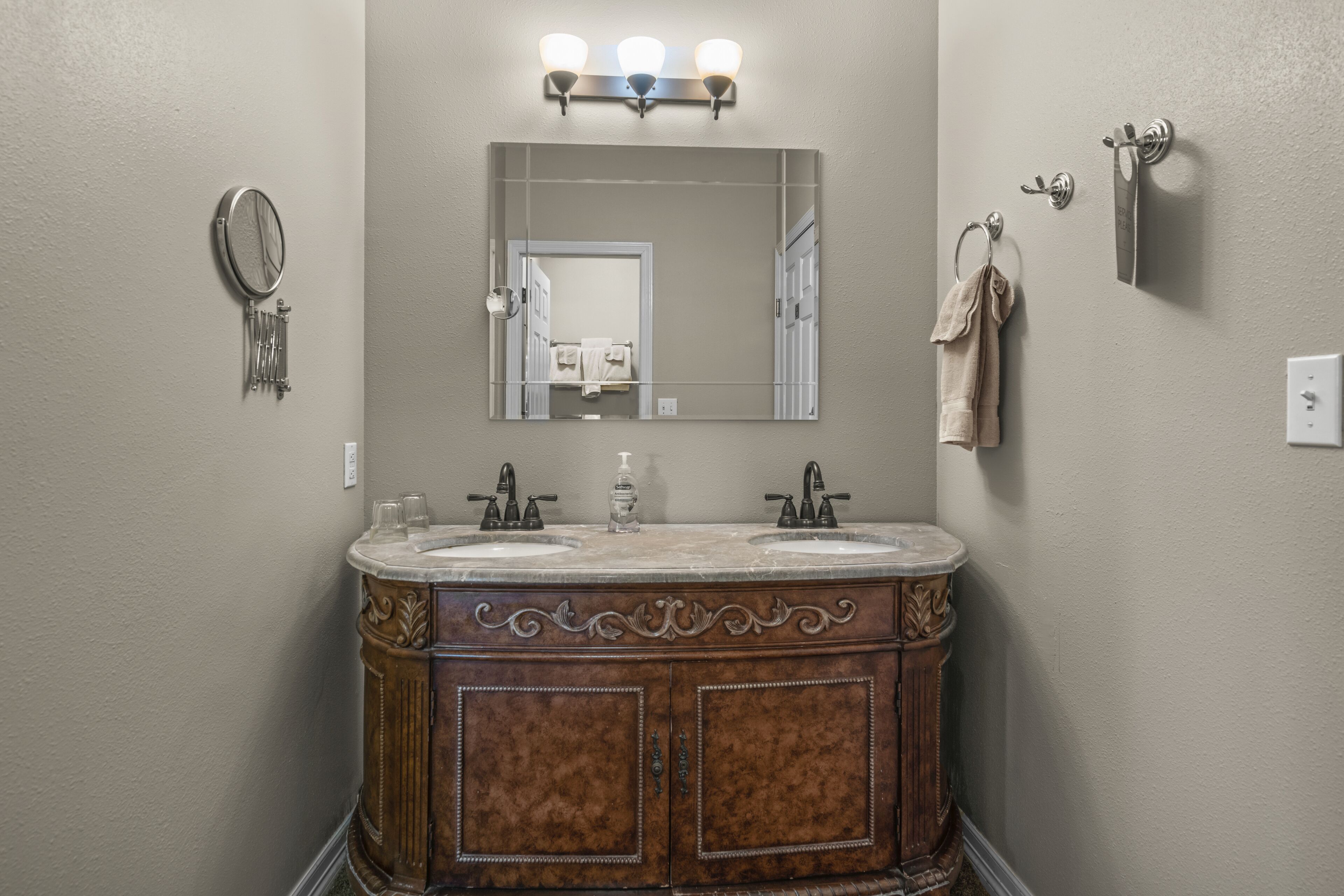 Une salle de bain avec un meuble-lavabo à deux vasques, un miroir et un porte-serviettes.